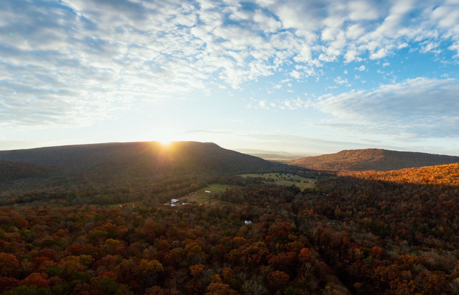 Sunrise over wooded ridge-and-valley terrain